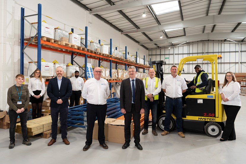 An image of Cllr James Lewis with a group of people who have taken on new green jobs thanks to the council's net-zero schemes. They are standing in a warehouse